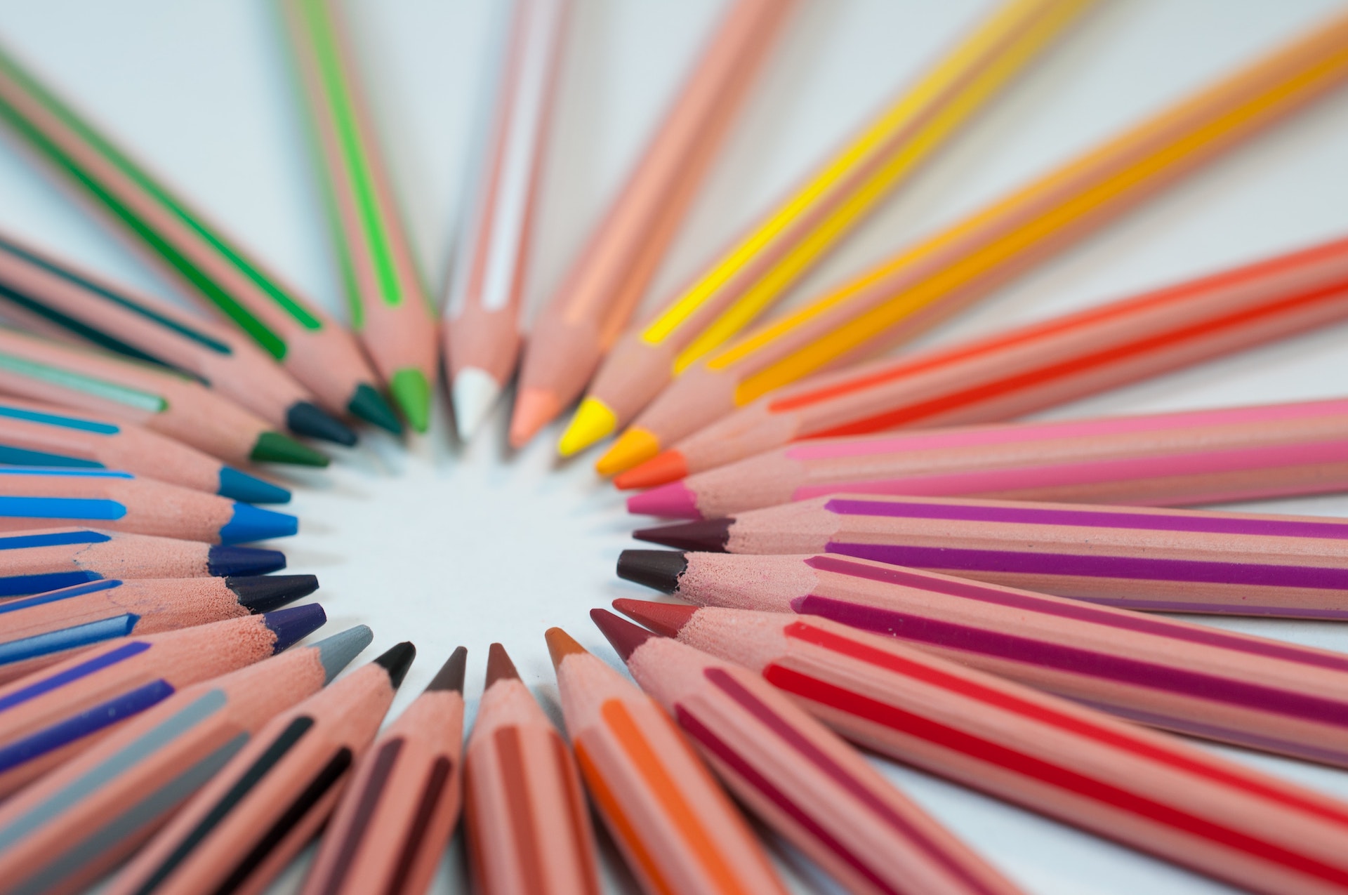 A close up shot of a complete collection of coloured pencils arranged in a circle