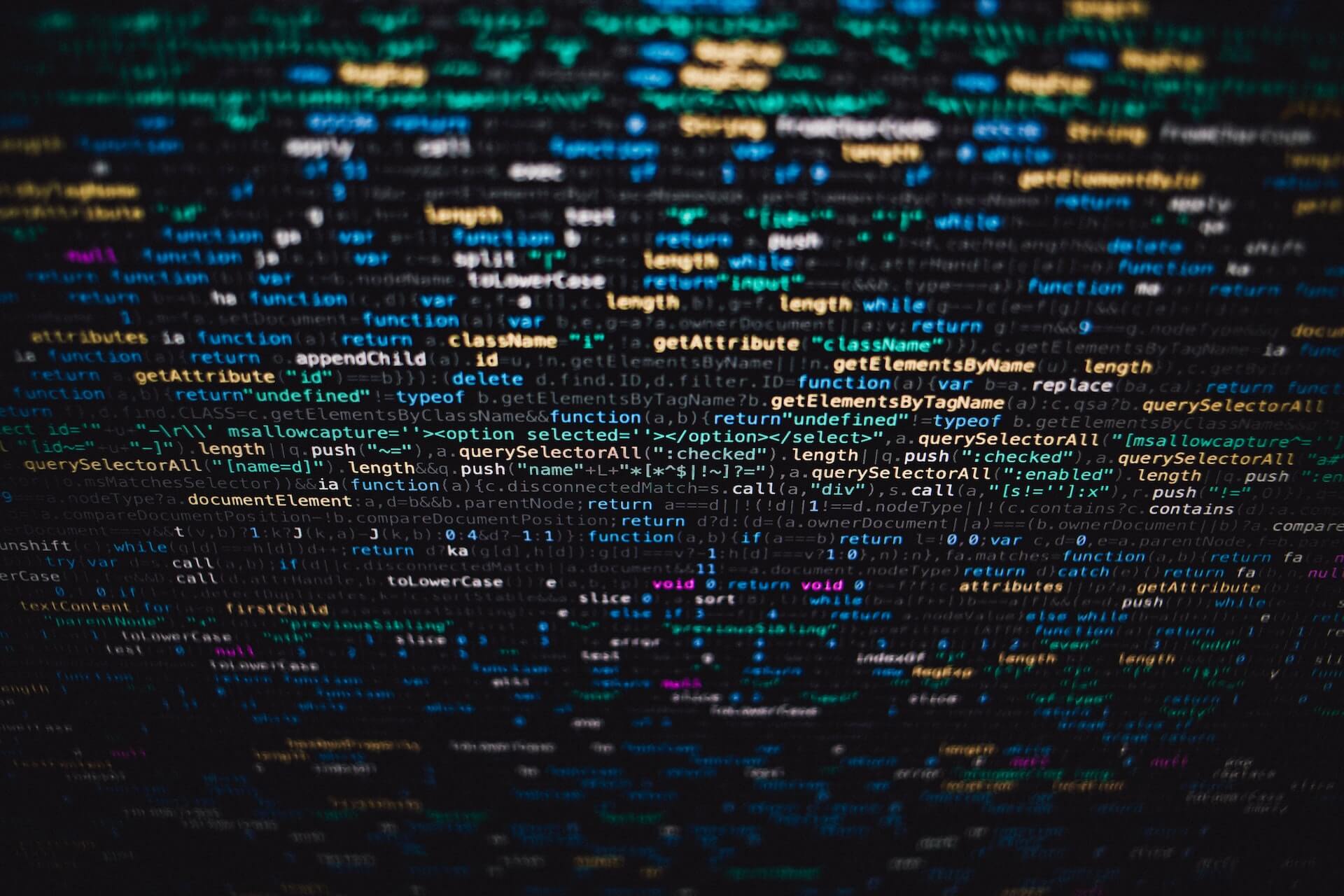 Wall of dense JavaScript code on a screen that blurs out at the edges
